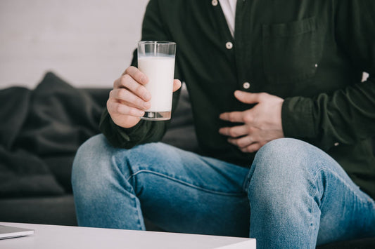 Man with Stomach Pain Holding Glass of Milk