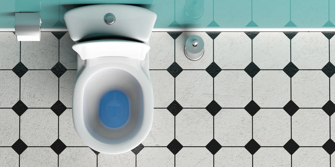 Overhead view of an open toilet beside black and white bathroom floor tiles.