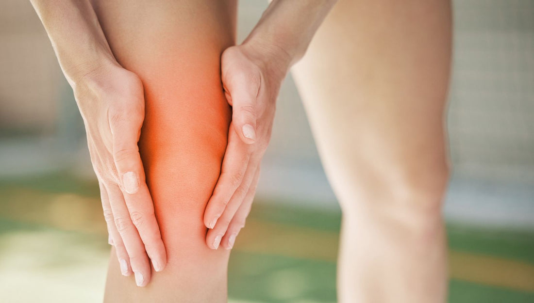 Person Holding a Painful Knee With the Area Highlighted in Red