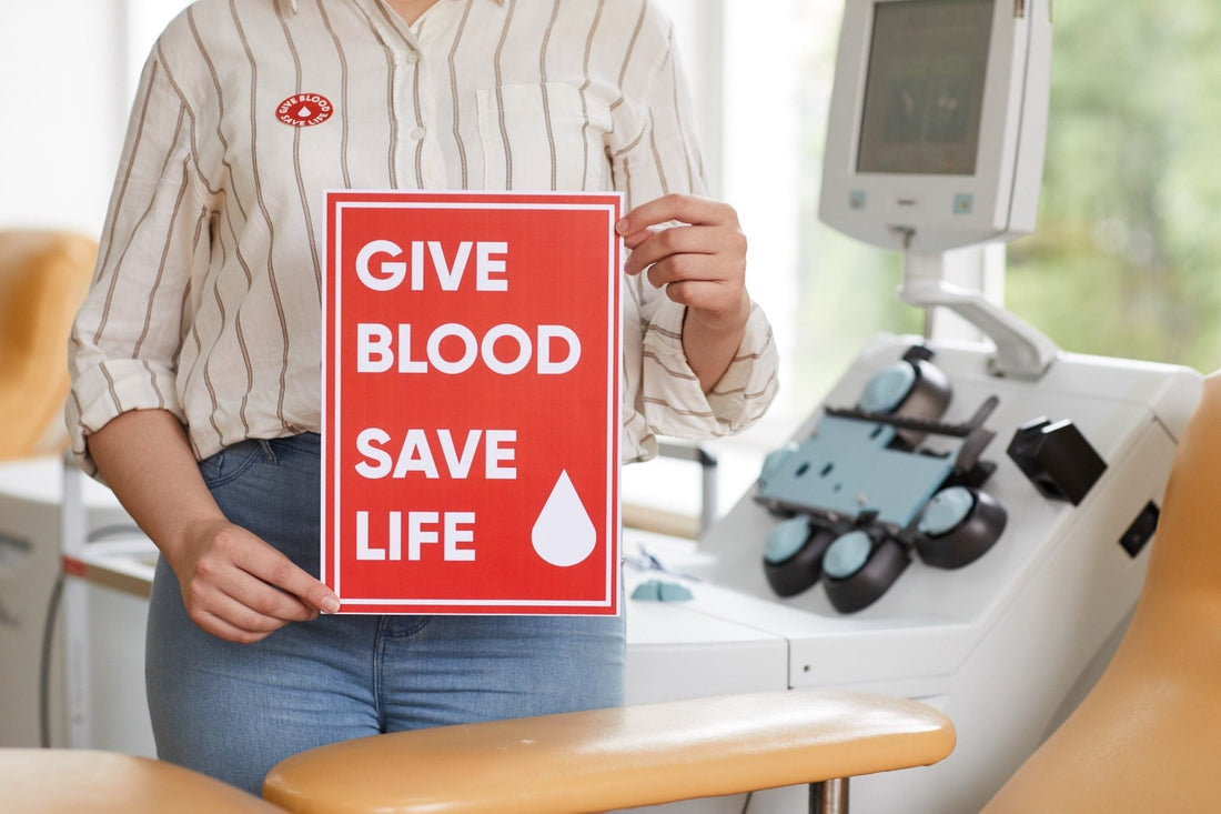 Person Holding Sign Saying "Give Blood Save Life"