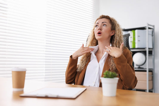Woman Experiencing a Hot Flush at Her Desk