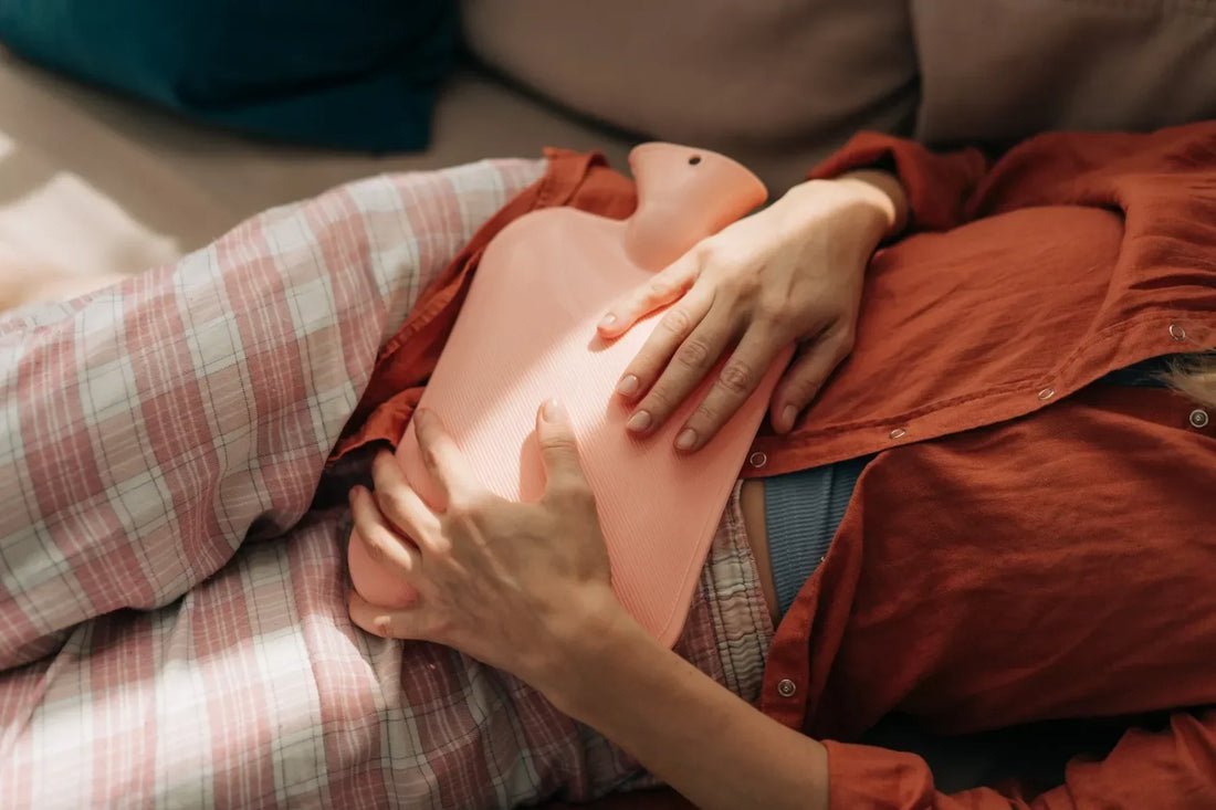 Woman Holding a Hot Water Bottle Against Her Abdomen