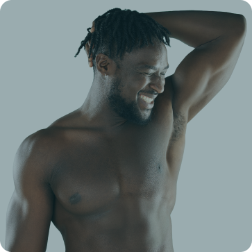 Man with braided hair touching his head against a gray background