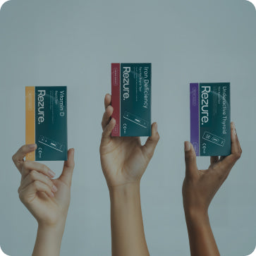Three hands holding Rezure product boxes against a gray background