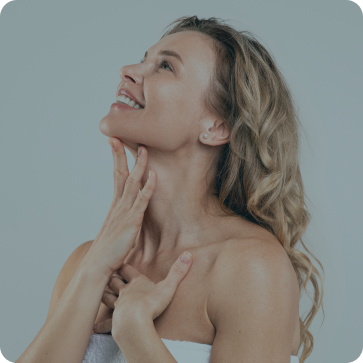 Woman touching her neck against a light gray background